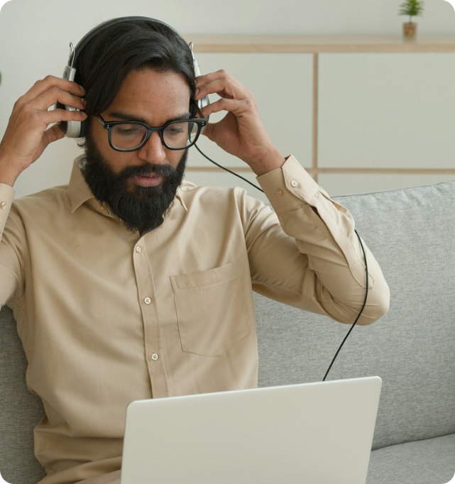 Asian businessman working online with laptop while sitting on couch.